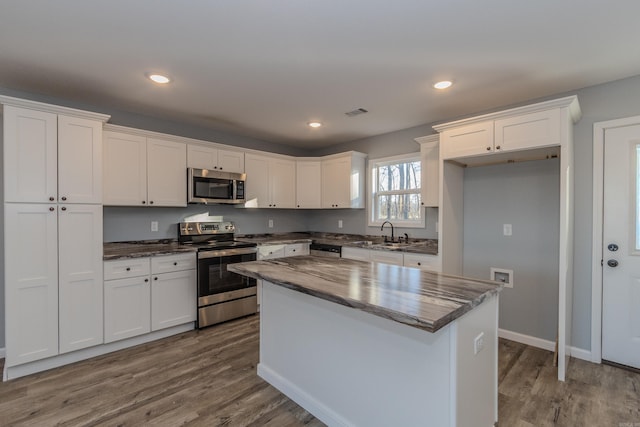 kitchen with white cabinets, a kitchen island, and appliances with stainless steel finishes