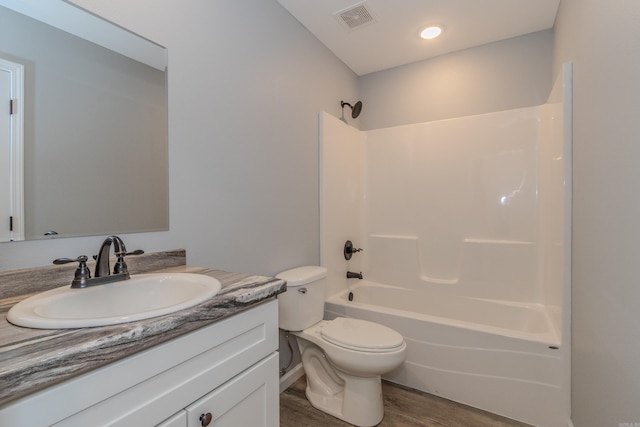 full bathroom featuring vanity, toilet, wood-type flooring, and shower / washtub combination