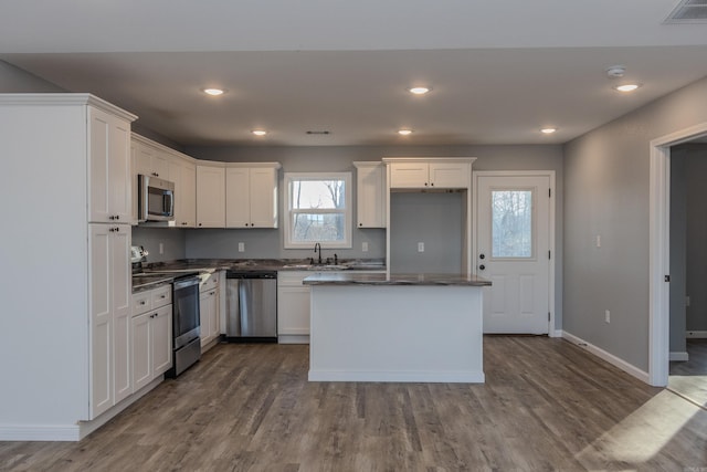 kitchen with a center island, sink, white cabinetry, and stainless steel appliances