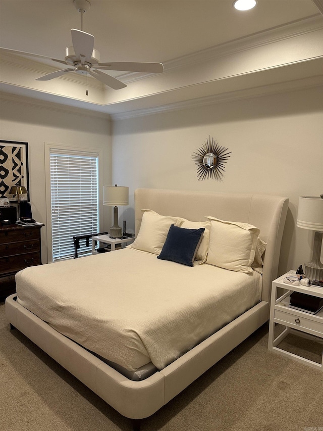 bedroom featuring carpet, ceiling fan, ornamental molding, and a tray ceiling