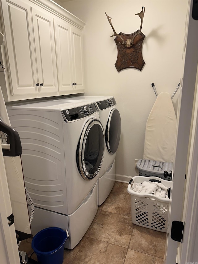 washroom with washer and dryer and cabinets