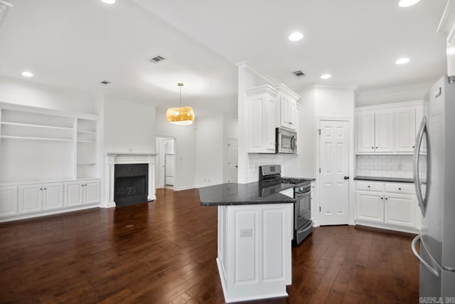 kitchen with decorative backsplash, white cabinetry, hanging light fixtures, and appliances with stainless steel finishes