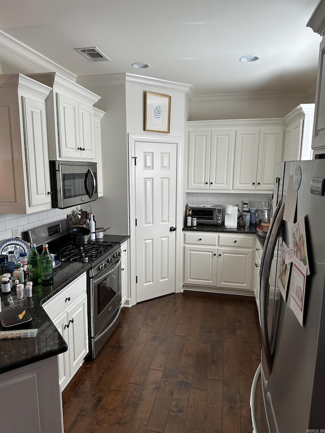 kitchen with backsplash, dark wood-type flooring, white cabinets, crown molding, and stainless steel appliances