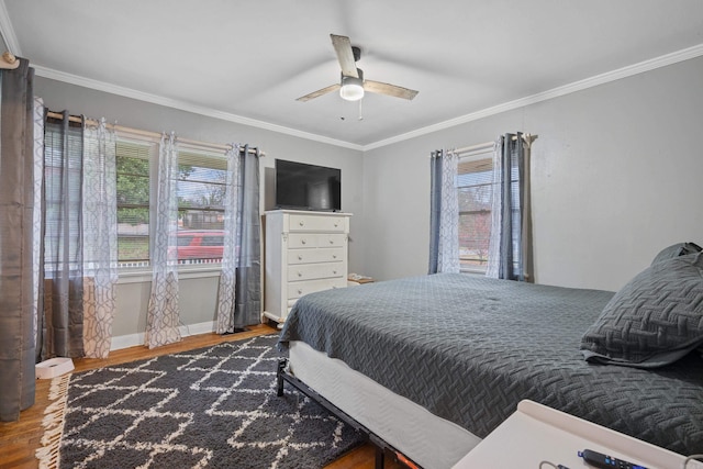 bedroom featuring multiple windows, hardwood / wood-style floors, ceiling fan, and crown molding