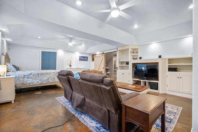 living room featuring a tray ceiling, a barn door, ceiling fan, and built in features