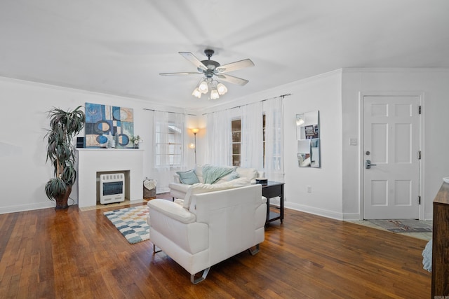 living room with heating unit, crown molding, and dark hardwood / wood-style flooring