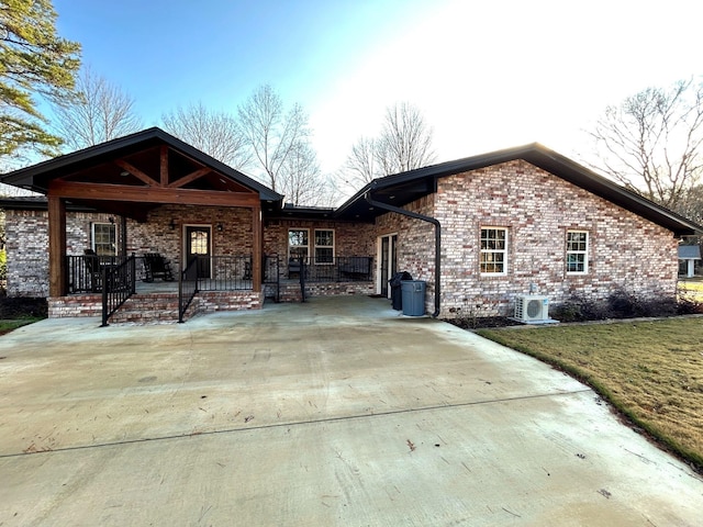 view of front of home with ac unit, a porch, and a front yard