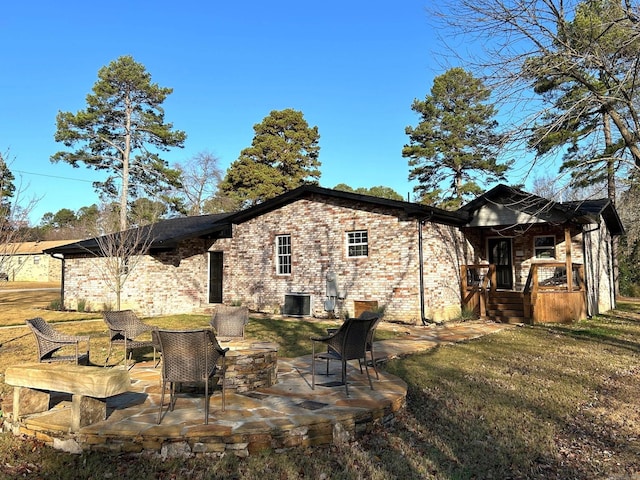 rear view of property featuring a patio area, a yard, and cooling unit