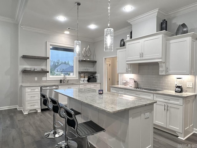 kitchen featuring a center island, sink, stainless steel dishwasher, a breakfast bar, and white cabinets