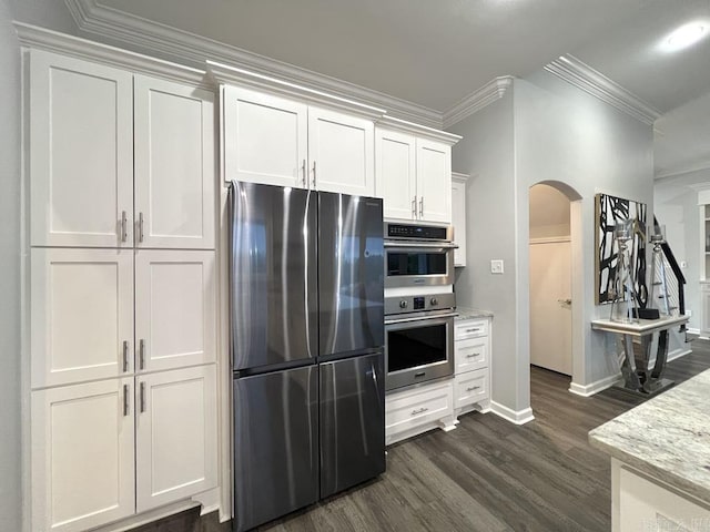 kitchen featuring white cabinets, crown molding, dark hardwood / wood-style flooring, light stone counters, and stainless steel appliances