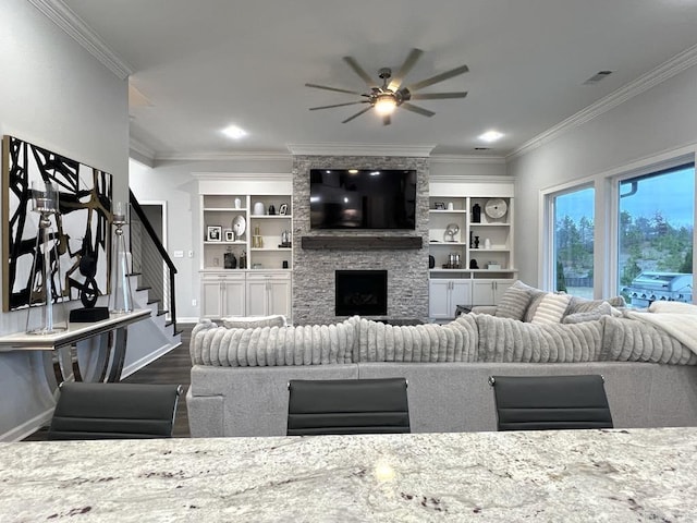 living room featuring crown molding, a fireplace, ceiling fan, and dark wood-type flooring