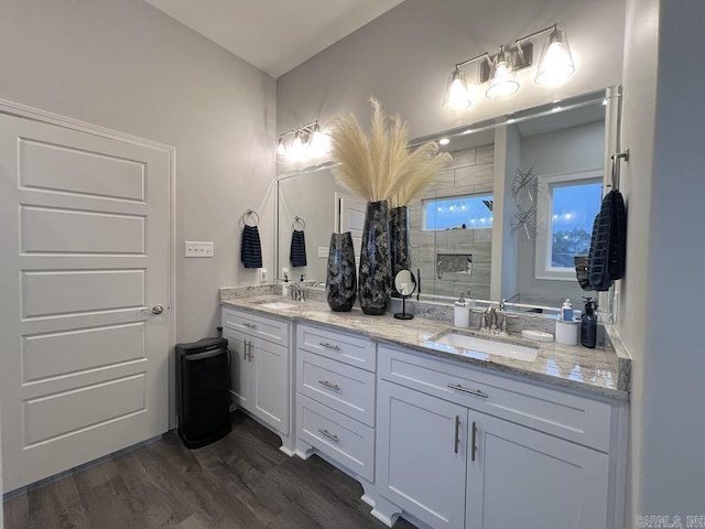 bathroom with hardwood / wood-style floors, vanity, and a shower