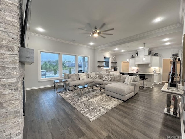 living room with dark hardwood / wood-style flooring, ceiling fan, and ornamental molding