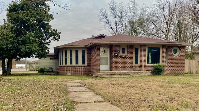 view of front facade featuring brick siding and a front lawn