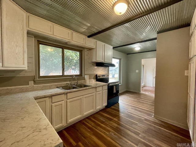 kitchen featuring under cabinet range hood, range with electric cooktop, light countertops, and a sink