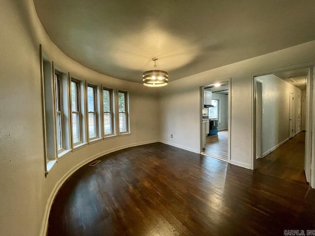 spare room with dark wood-style floors and baseboards