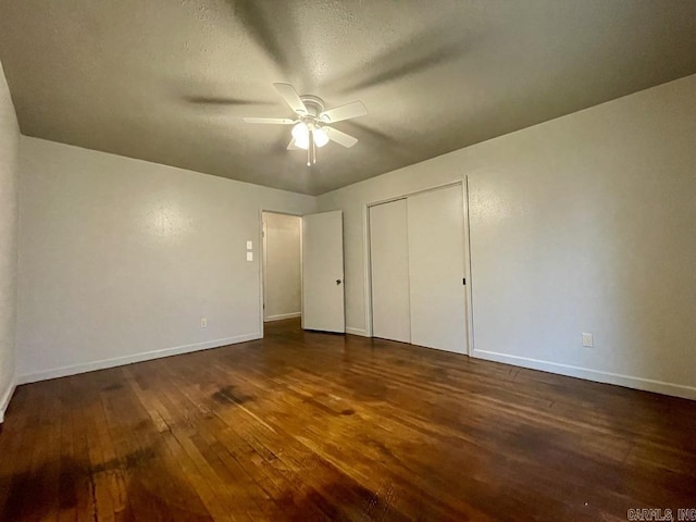 unfurnished bedroom with ceiling fan, a textured ceiling, baseboards, a closet, and hardwood / wood-style floors