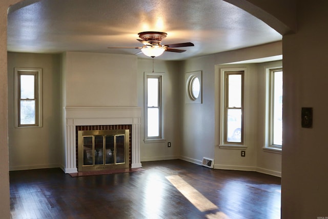 unfurnished living room featuring a fireplace with flush hearth, plenty of natural light, and dark wood-style floors