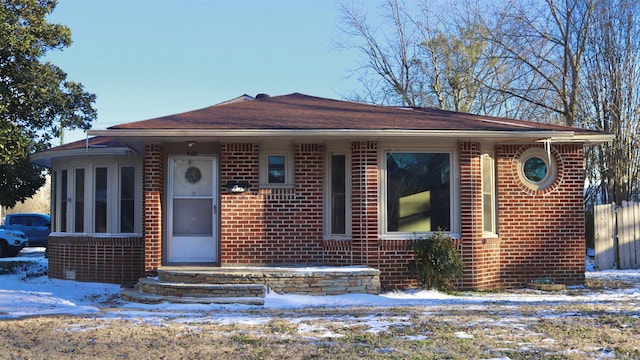 bungalow with fence and brick siding