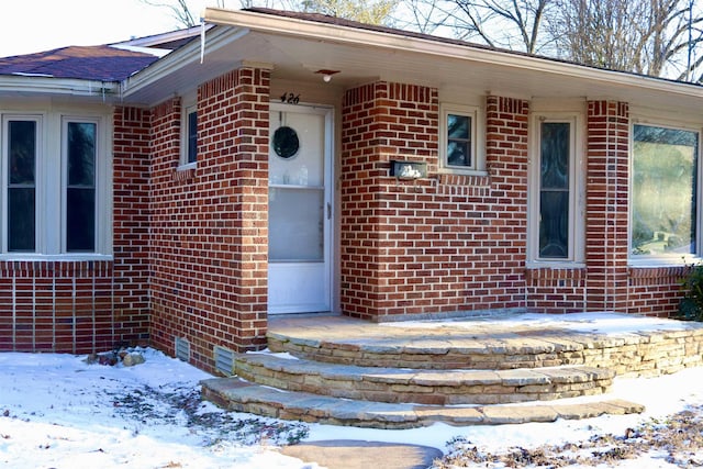 doorway to property featuring brick siding