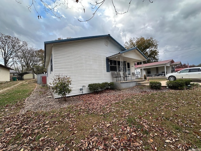 view of side of property with a lawn and a porch