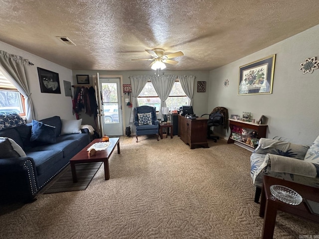 carpeted living room with a textured ceiling and ceiling fan