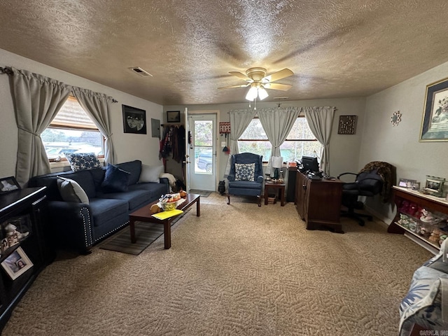 carpeted living room featuring a textured ceiling and ceiling fan