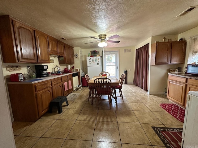 kitchen with ceiling fan, sink, a textured ceiling, white appliances, and light tile patterned flooring