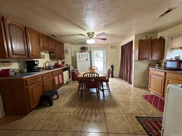 kitchen with white appliances, sink, ceiling fan, a textured ceiling, and light tile patterned flooring