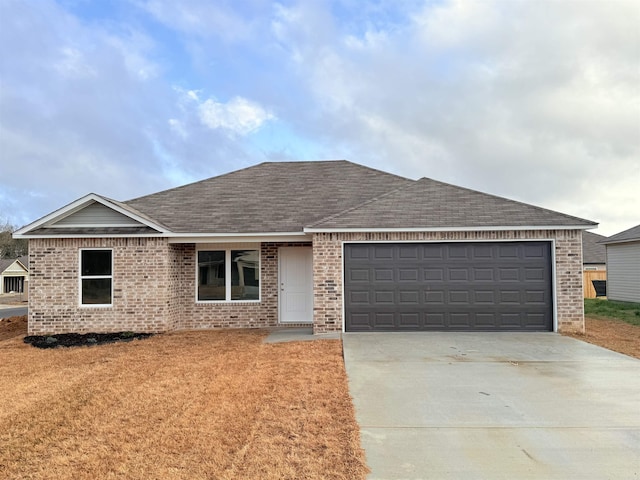 single story home with a garage, concrete driveway, brick siding, and roof with shingles