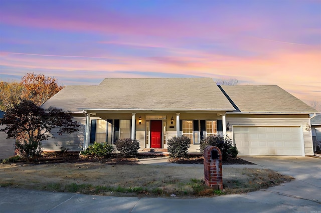 ranch-style house featuring covered porch and a garage