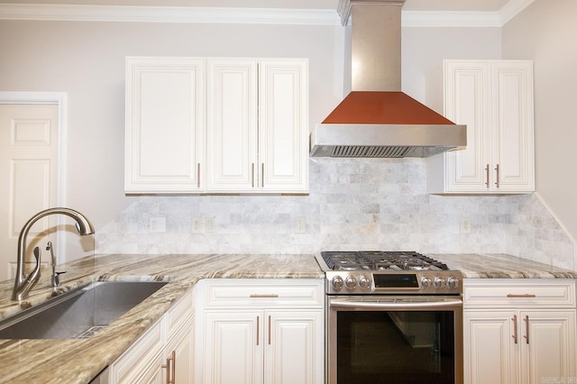 kitchen with wall chimney range hood, sink, white cabinets, and stainless steel range with gas stovetop