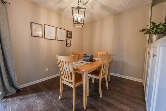 dining room featuring a textured ceiling, a notable chandelier, and dark wood-type flooring