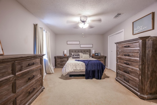 carpeted bedroom with a textured ceiling and ceiling fan