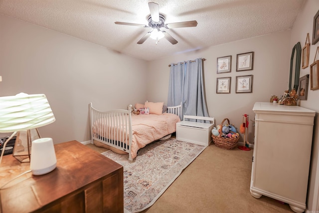 bedroom featuring carpet flooring, a textured ceiling, and ceiling fan