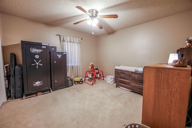 game room featuring light carpet, ceiling fan, and a textured ceiling