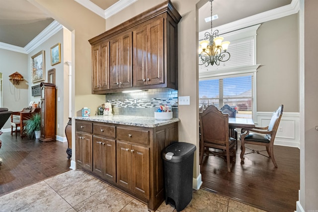 kitchen with crown molding, backsplash, and light hardwood / wood-style flooring