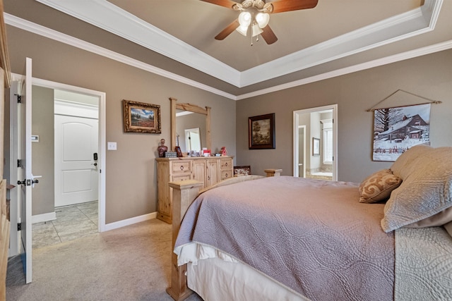 bedroom featuring connected bathroom, ceiling fan, a tray ceiling, light carpet, and ornamental molding