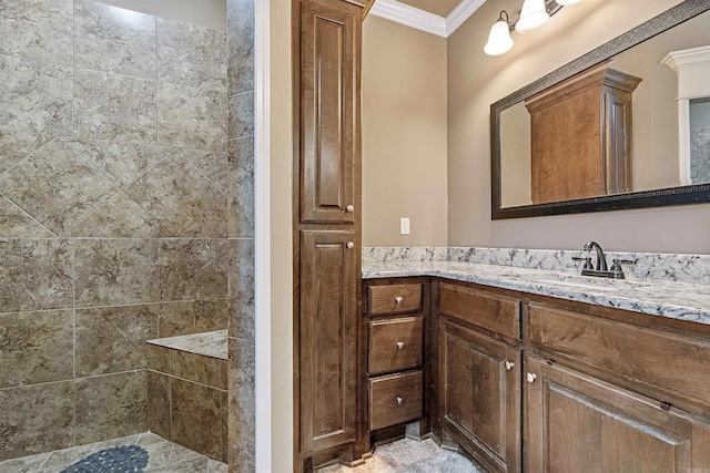 bathroom with a tile shower, vanity, and ornamental molding