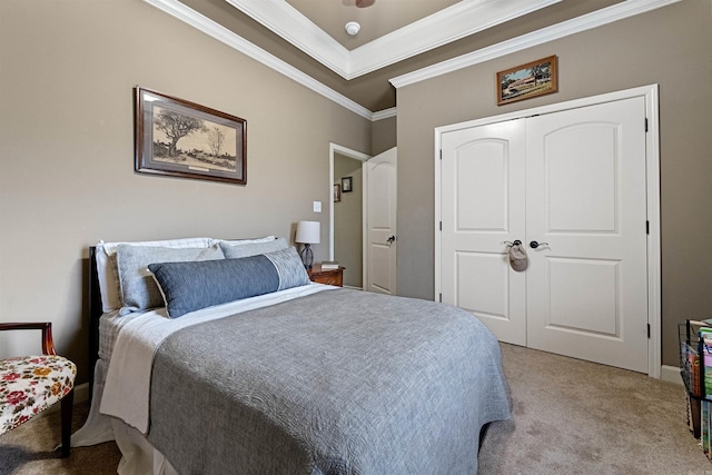 carpeted bedroom featuring ceiling fan, crown molding, and a closet