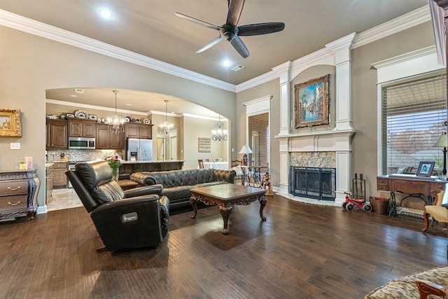 living room with a stone fireplace, ceiling fan, ornamental molding, and hardwood / wood-style flooring