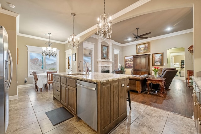 kitchen with stainless steel appliances, ceiling fan, sink, a center island with sink, and light hardwood / wood-style flooring