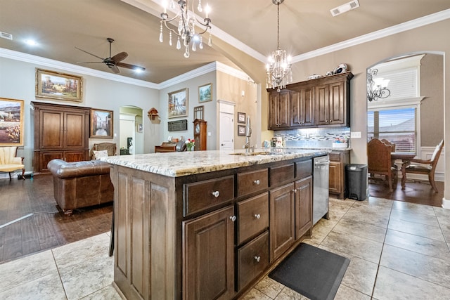 kitchen with a center island with sink, hanging light fixtures, crown molding, and light hardwood / wood-style floors