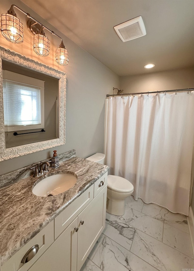 bathroom featuring walk in shower, vanity, and toilet