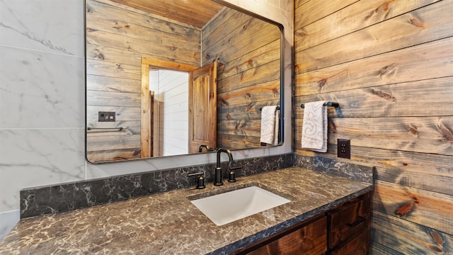 bathroom featuring vanity and wooden walls