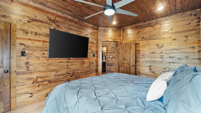 bedroom with ceiling fan, wood ceiling, wood walls, and wood-type flooring