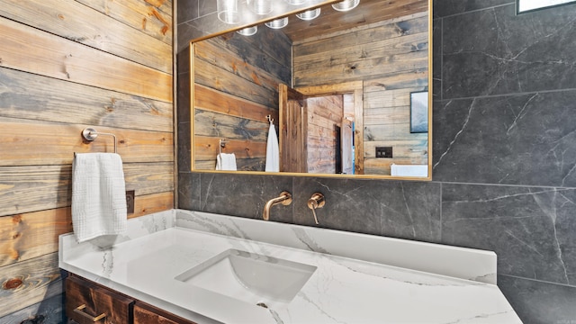 bathroom with vanity and wooden walls