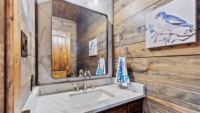 bathroom featuring wood walls and vanity