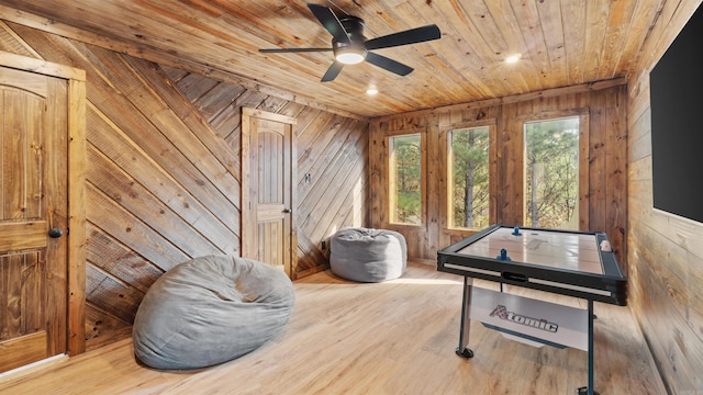 game room featuring hardwood / wood-style flooring, ceiling fan, wood walls, and wood ceiling