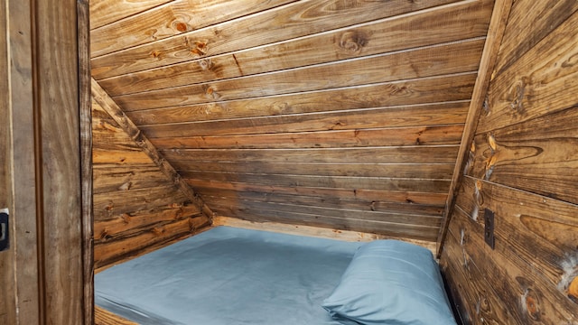 unfurnished bedroom featuring wood walls and lofted ceiling